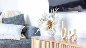 A wooden cabinet with a vase of dried flowers and wooden letters spelling 'love' on top. - Beachside Bliss 3BDR mins to Caves Beach & Bistros (Caves Beach)