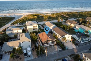 An aerial view of a coastal residential area with houses, a beach, and a road. - Luxury Oceanfront 2 bed | Hot Tub + Private Deck (Saint Augustine)