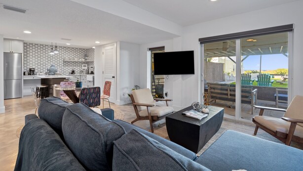 A modern living space with a kitchen, dining area, and a balcony with a view. - Oceanfront Ground Level Apt | Patio + Beach Access (St. Augustine)