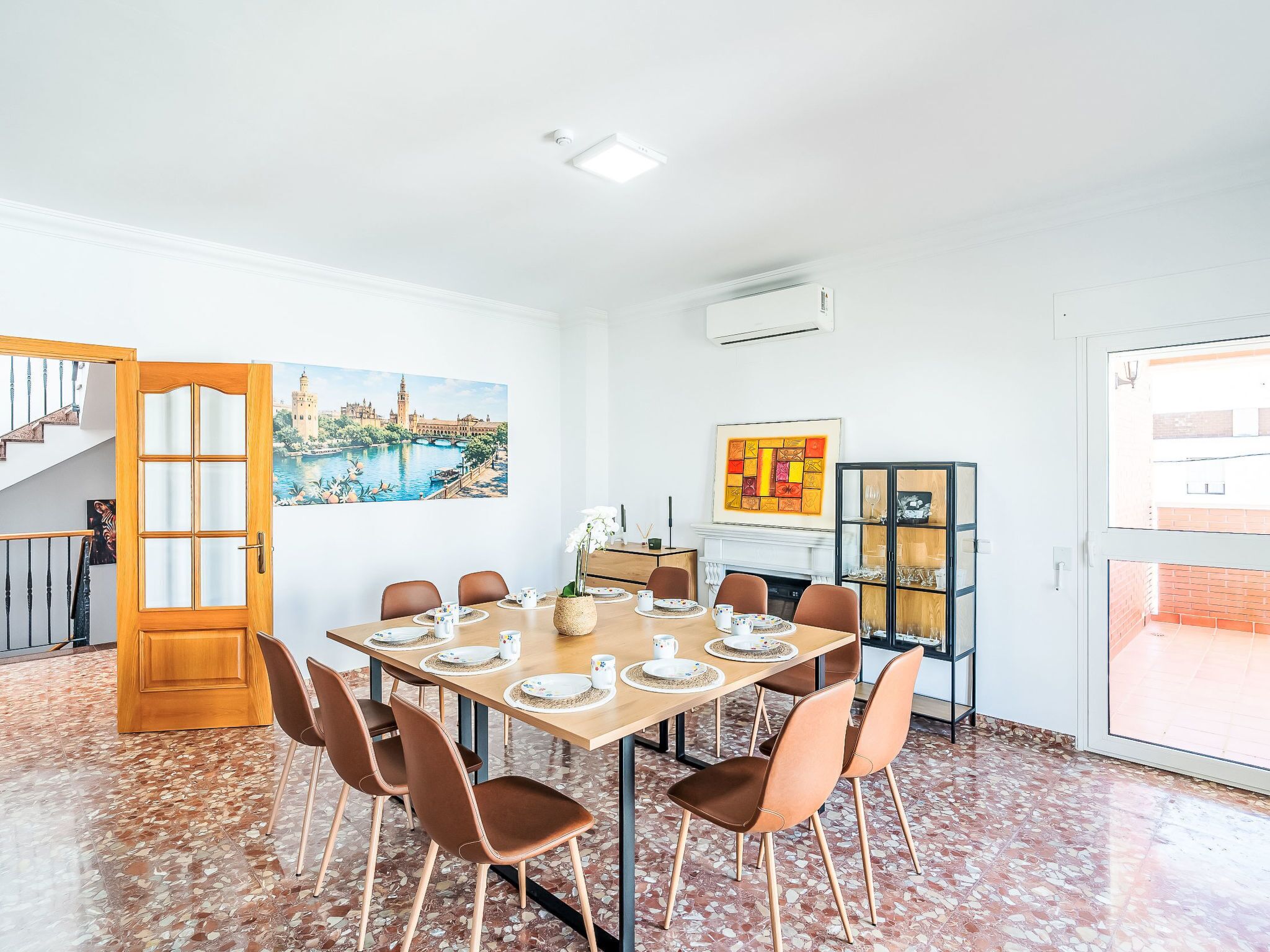 Un comedor con una mesa dispuesta para seis personas, rodeada de sillas, una chimenea y vistas a un río.