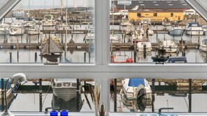 A marina with boats docked, a yellow building, and a view through a window. - "Pejo" - 10m from the sea by Interhome (Glesborg)