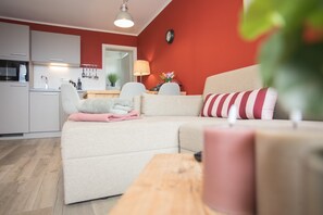 A modern living room with a sofa, a wooden coffee table, and a kitchen in the background. - Apartment - Winterbergerstrasse 3 nr 505 (Winterberg)