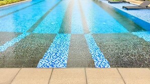 A swimming pool with a tiled pattern, surrounded by high-rise buildings. - GTC  2-bedroom apartment with AC in lovely  Nairobi,Westlands neighborhood (Nairobi)