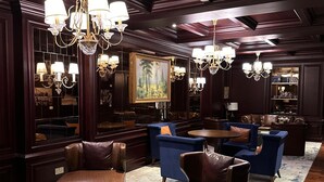 A luxurious lounge area with leather seating, chandeliers, and a large painting on the wall. - GTC  2-bedroom apartment with AC in lovely  Nairobi,Westlands neighborhood (Nairobi)