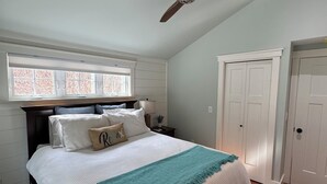A bedroom with a bed, a ceiling fan, a window, and a door. - Golden View lake house on Crawford Pond (Union)