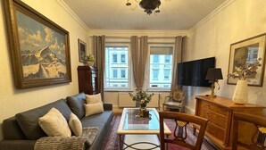 Un salon avec un canapé, une table basse, un téléviseur et une cheminée.