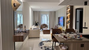 Un salon moderne comprenant un canapé, une table basse et un coin repas avec des chaises et un téléviseur.