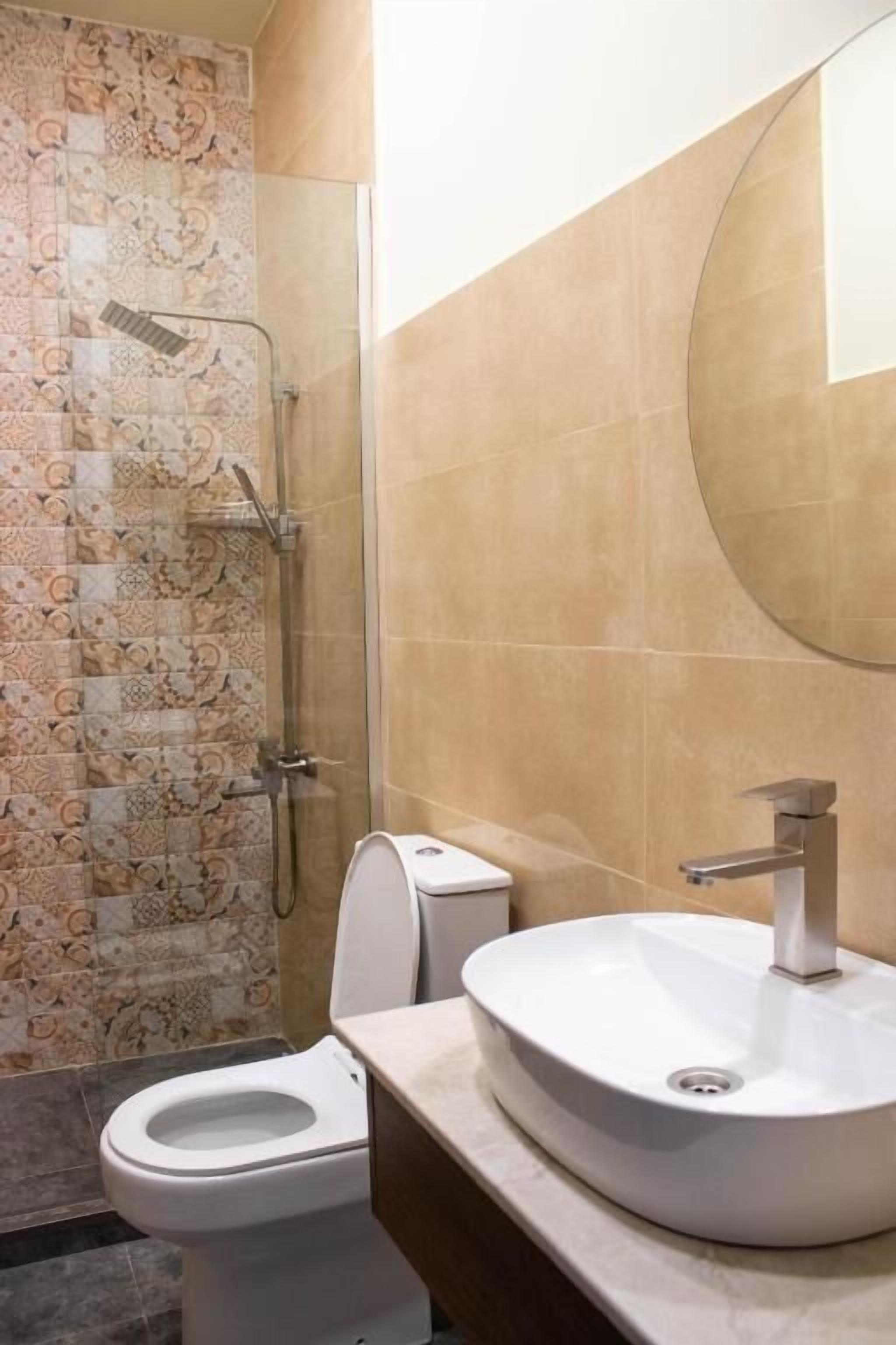 A bathroom with a shower, toilet, and sink.