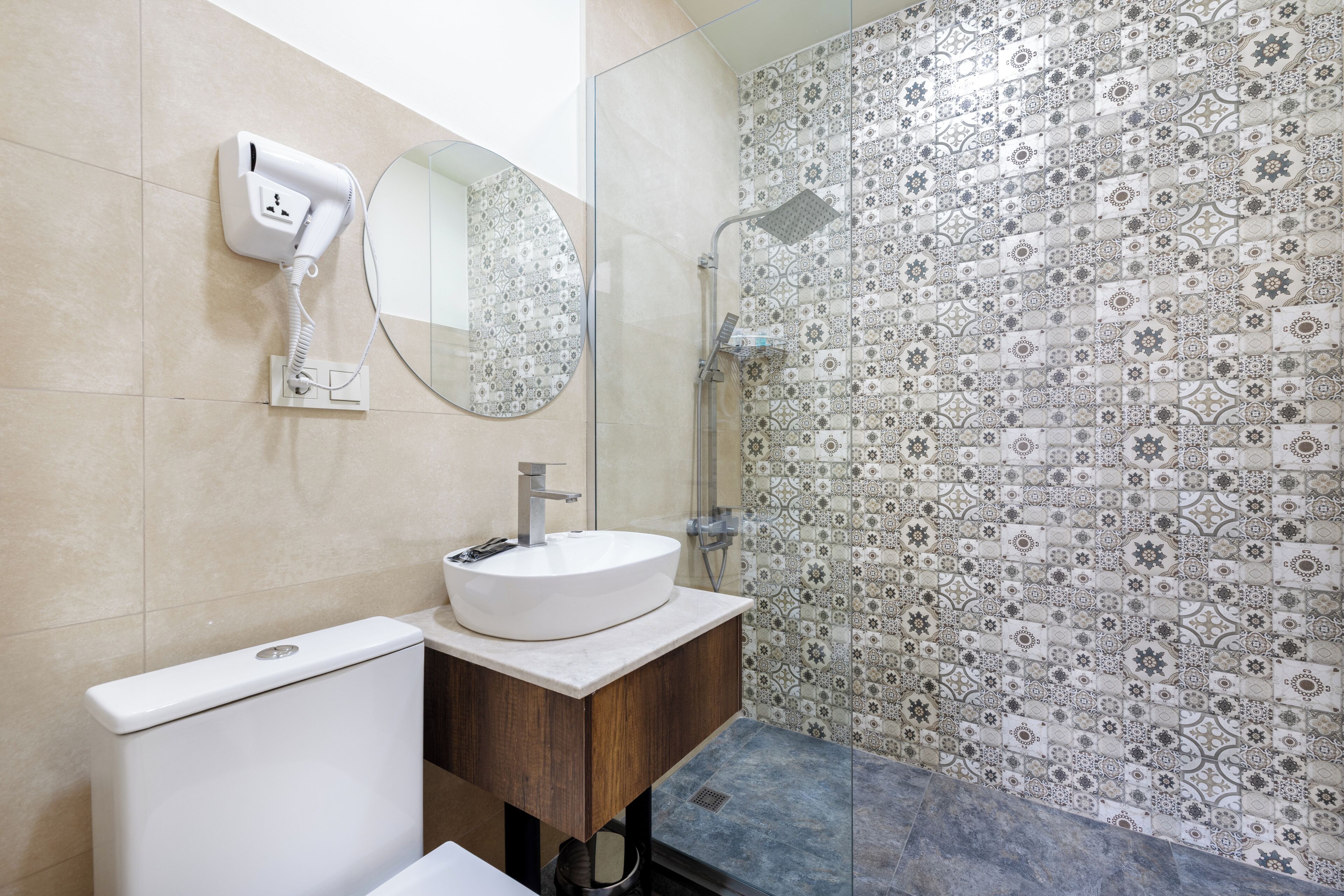 Un baño con lavamanos blanco, un espejo, ducha e inodoro.