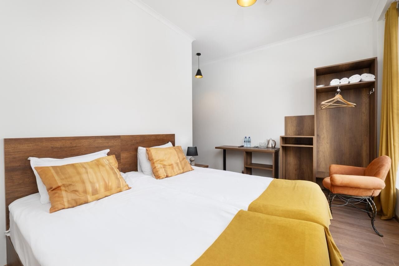 Una habitación de hotel con cama, escritorio, silla y armario.