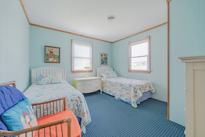 A bedroom with two beds, a nightstand, a dresser, and a crib. - JL #656 | Terrill Cottage | Semi-Oceanfront | Horizon Ocean View (Kitty Hawk)