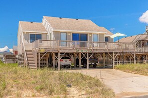 A two-story building with a wooden deck and a garage. - JL #656 | Terrill Cottage | Semi-Oceanfront | Horizon Ocean View (Kitty Hawk)