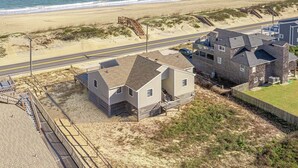 Ein Strandgrundstück mit Strandhaus, einer Straße und einer Strandpromenade.