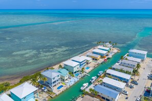 A coastal residential area with houses, a marina, and clear turquoise waters. - Ocean Views,  Pool, 45’ Dock, Kayaks & 3 Suites (Marathon)