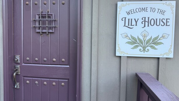 A purple door with a metal latch and a sign that reads 'Welcome to the Lily House.' - Pacific Coast Highway Lily House (San Luis Obispo)