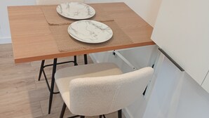 A dining table with two plates, a chair, and a kitchen cabinet.