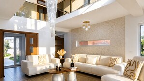 Una sala de estar moderna con un sofá modular, una mesa de centro y una araña.