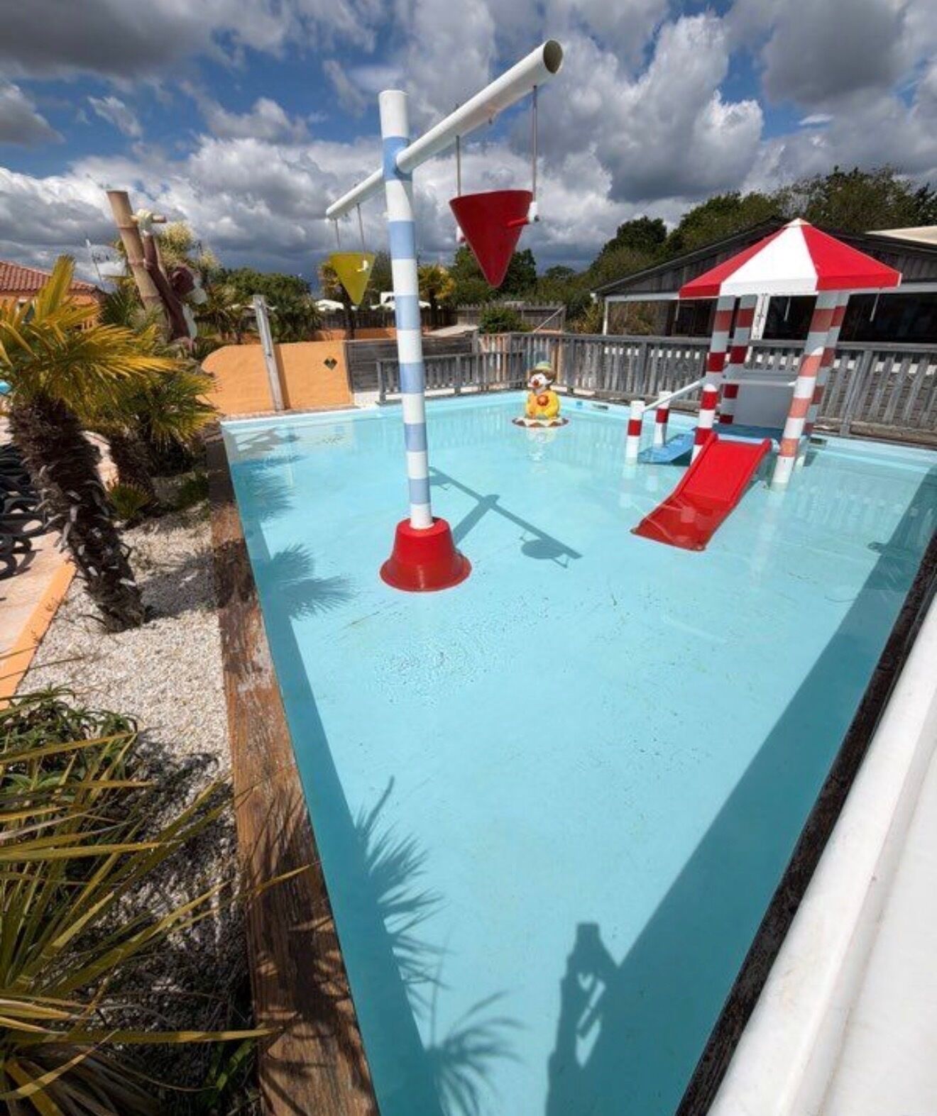 A swimming pool with slides and a small water play area.