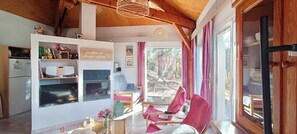 A cozy living area with a fireplace, wooden beams, and a view of the outdoors. - Villa at Domaine de l'Espinet - Quillan 11500 (Quillan)