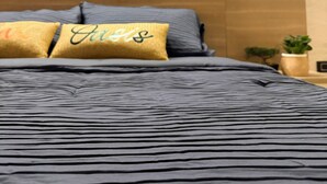 A bed with a dark blue bedspread and two pillows, one with a golden fabric and the other with a golden fabric and the word 'Aisle' embroidered. - ! House in Santa Fe de Antioquia Patio Colonial Boutique (Santa Fé de Antioquia)