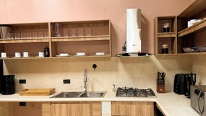 A kitchen with a stone floor, wooden cabinets, a sink, a stove, and a microwave. - ! House in Santa Fe de Antioquia Patio Colonial Boutique (Santa Fé de Antioquia)