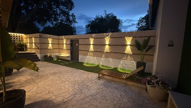 A patio area with stone flooring, a wooden lounge chair, and potted plants. - ! House in Santa Fe de Antioquia Patio Colonial Boutique (Santa Fé de Antioquia)
