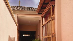 A narrow corridor with a tiled floor, a potted plant, and a wooden gate. - ! House in Santa Fe de Antioquia Patio Colonial Boutique (Santa Fé de Antioquia)