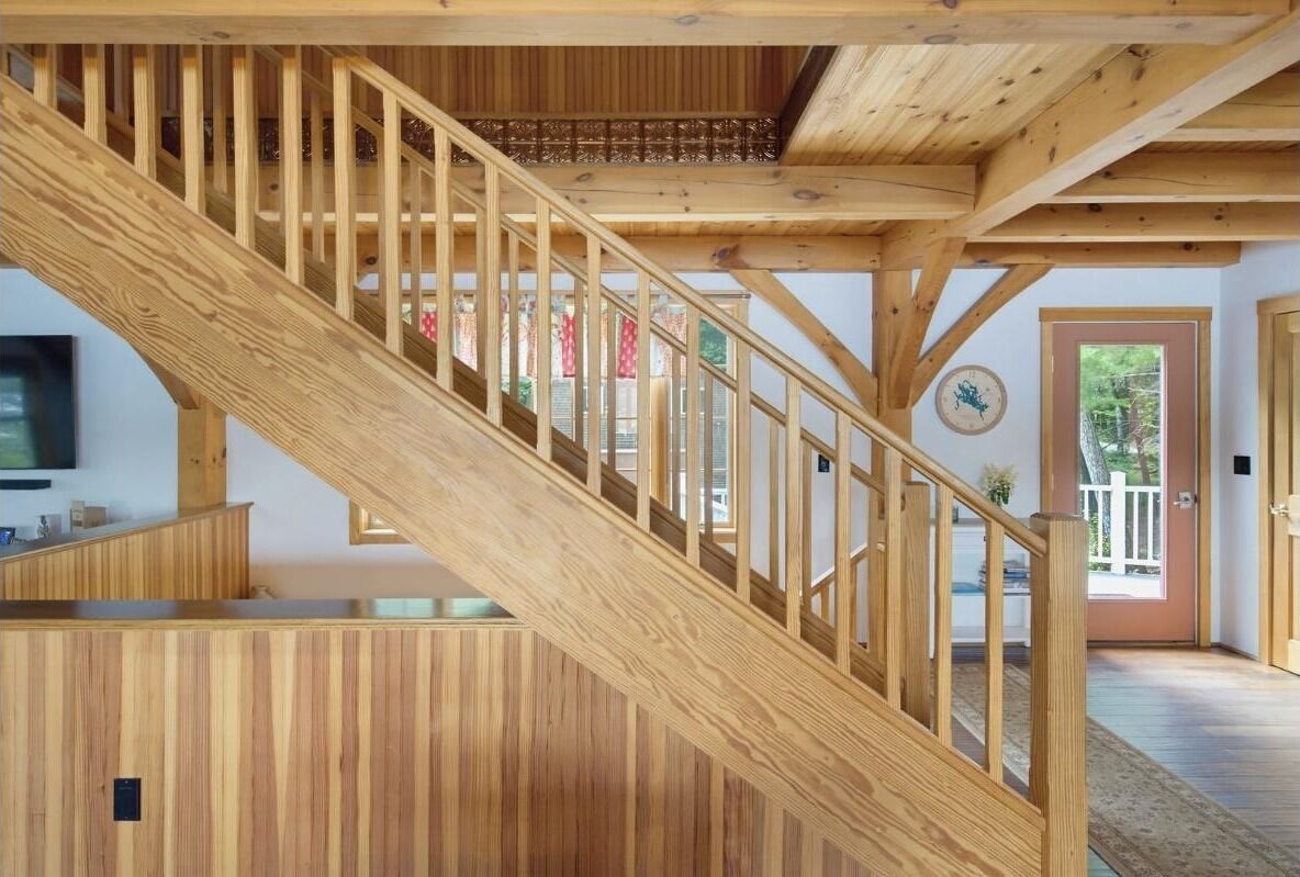The open staircase showcases the home's post-and-beam craftsmanship.