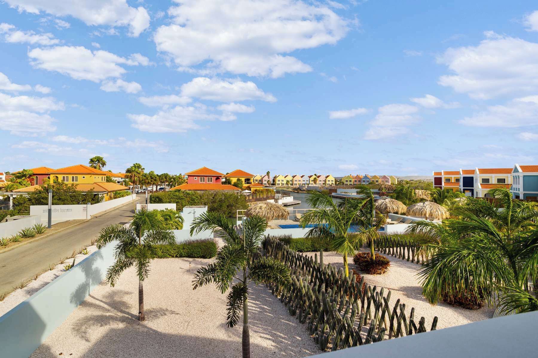 A resort with colorful buildings, a swimming pool, and a cactus garden.