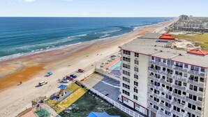 A high-rise hotel with a beach view, a parking area, and a pool. - The Vista: Oceanfront studio~View~King bed~Pool~Gym (Daytona Beach)