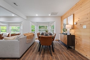 Un intérieur moderne comprenant un coin repas, un canapé et un mur en bois.