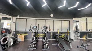 Ein Fitnessraum mit Ergometer, einer Bank und Gewichten.