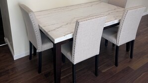 A dining table with four upholstered chairs, dark wooden legs, and a marble-like tabletop. - Superb 2-bedroom country house in charming Pittsburgh with AC (Pittsburgh)