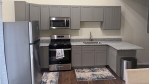 A modern kitchen with grey cabinets, stainless steel appliances, and a granite countertop. - Superb 2-bedroom country house in charming Pittsburgh with AC (Pittsburgh)