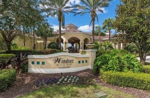 A landscaped area with a sign for Windsor Hills Clubhouse. - Disney Fun in the Sun! 4th Floor Relaxation Retreat! (Kissimmee)