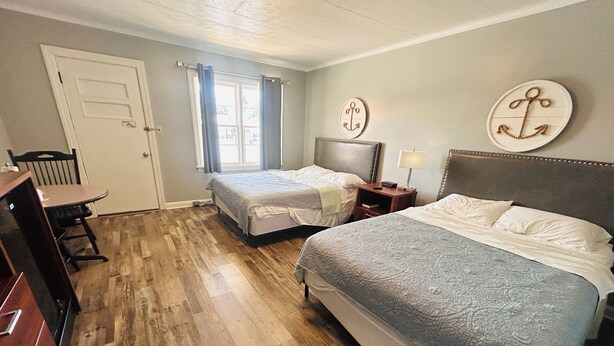 Una habitación de hotel con dos camas, un escritorio y una silla.