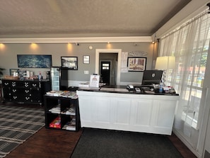 A reception desk with a computer, a 'Welcome to the Lake' sign, framed pictures on the wall, and a black and white checkered rug. - 7 Gables Motel Burnside Near Somerset US 27 (Burnside)