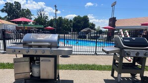 Zona de piscina con una parrilla y una estación de servicio al fondo.
