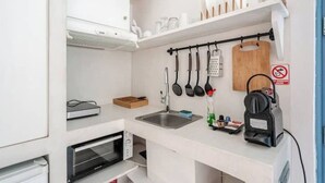 A compact kitchenette with a built-in oven, a sink, and a coffee maker. - Aura 1-bedroom apartment with AC and WiFi in charming Thira (Thira)