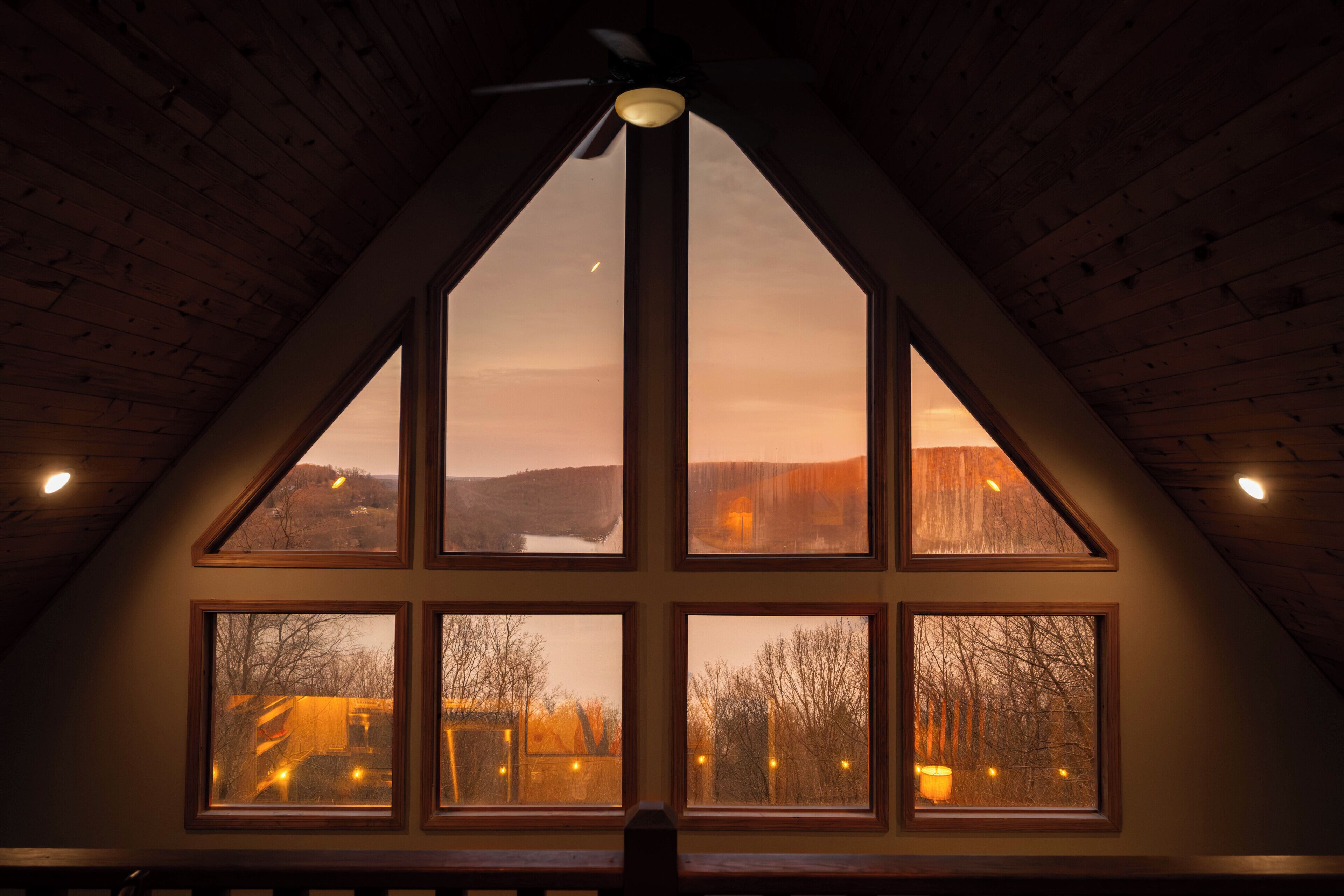A room with a sloped ceiling and multiple windows.