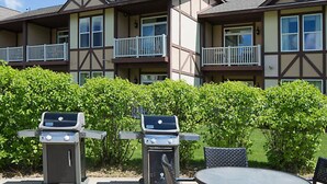 A multi-story building with balconies, outdoor grills, and a round table.