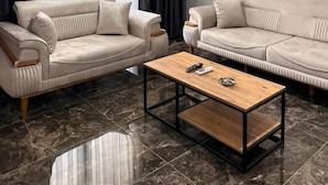 A modern living room with two sofas, a coffee table, and a ceiling light. - BLACK HOUSE OTEL TURİZM  (Mersin)