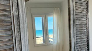 A room with a rustic wooden-framed window, a white wall, and a view of the beach. - PRECIOSO APARTAMENTO FRONTAL AL MAR - only families (Playa de Gandía)