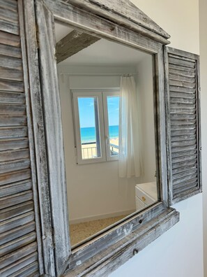A room with a rustic wooden-framed window, a white wall, and a view of the beach. - PRECIOSO APARTAMENTO FRONTAL AL MAR - only families (Playa de Gandía)