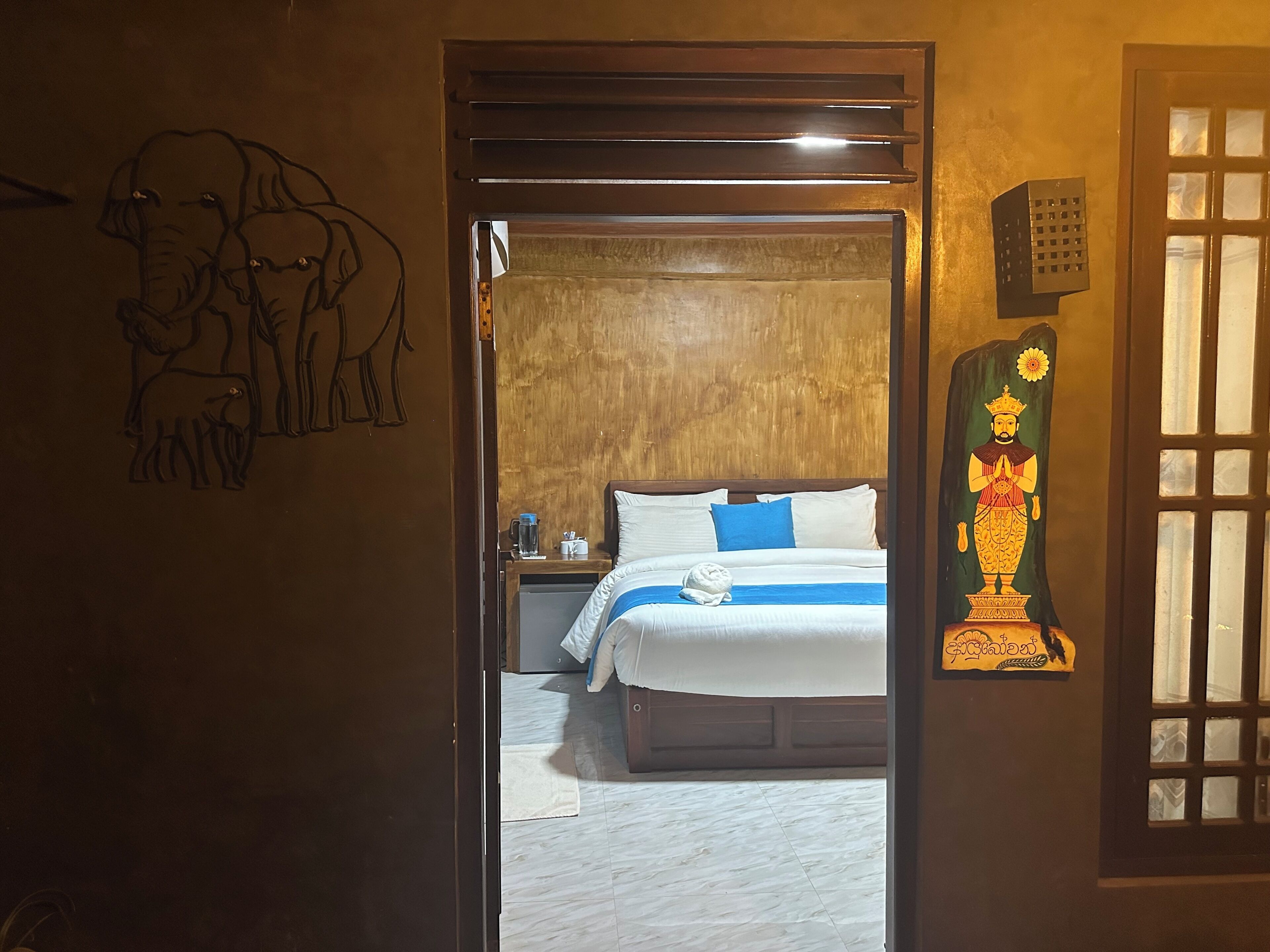 A bedroom with a bed, a nightstand, a wall painting, and a decorative piece.