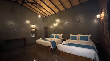 A hotel room with two beds, a wooden ceiling, and wall-mounted lighting.