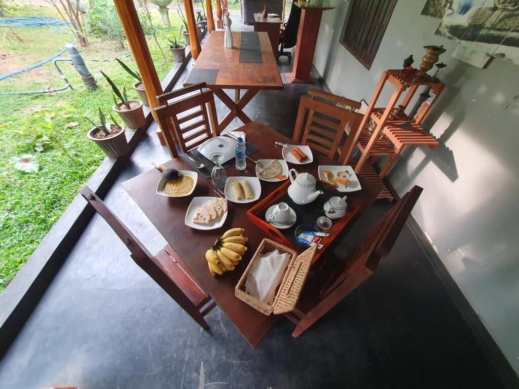 A dining area with a table set for breakfast, including plates, bowls, and a tray with teapots and cups.