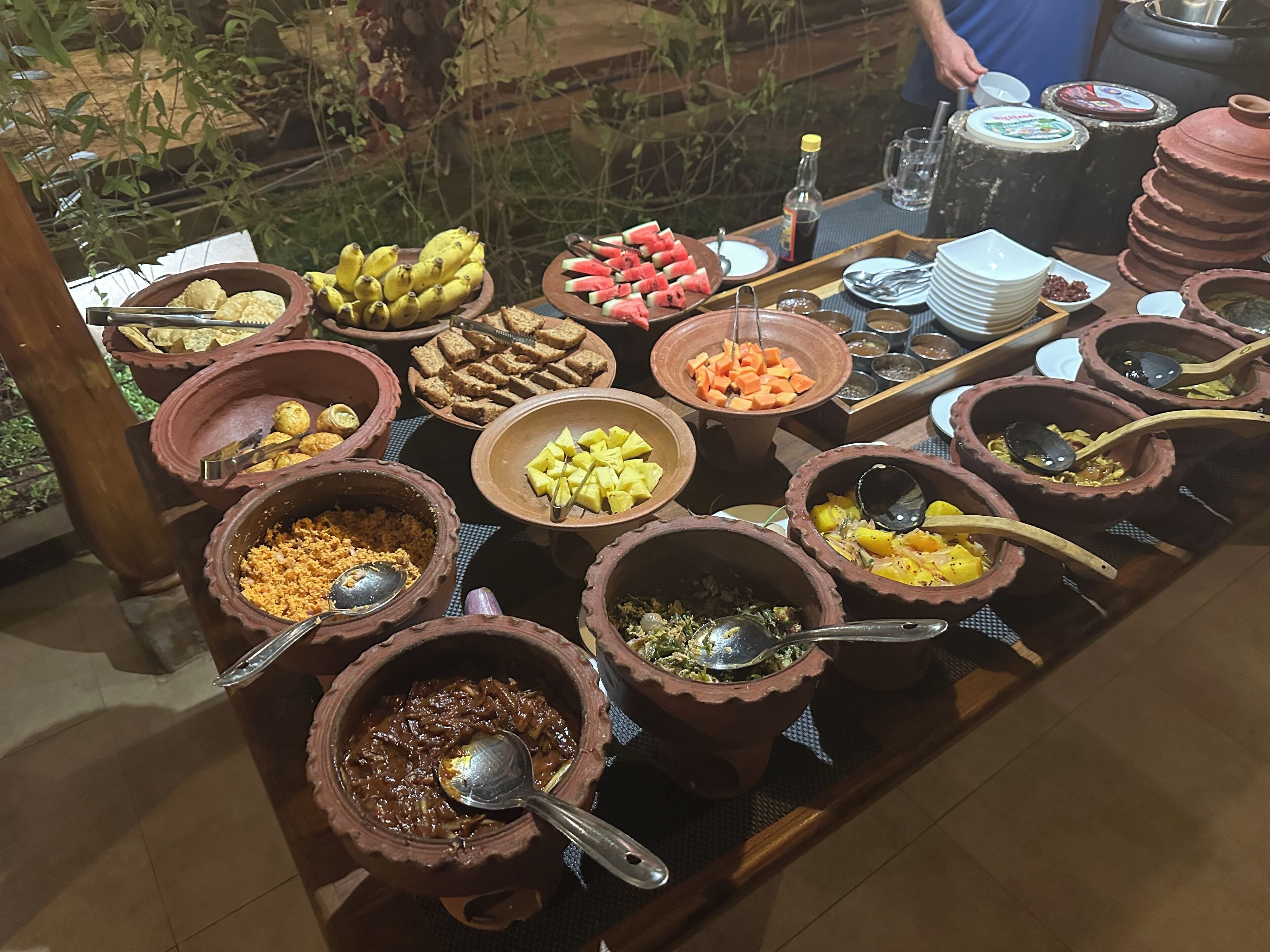 A buffet table with various food items and serving utensils.