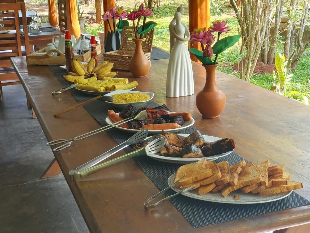 A wooden table with various dishes, utensils, and decorative items.