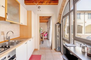 A narrow kitchen with a stainless steel sink, a stove, and wooden cabinets. - [Free parking] - 7 min from Juliet's | 4 people   (Verona)